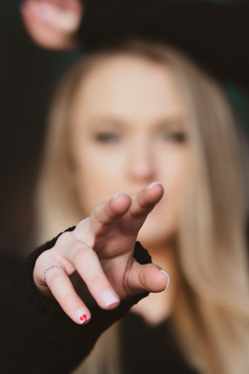 woman with blonde hair holding her face