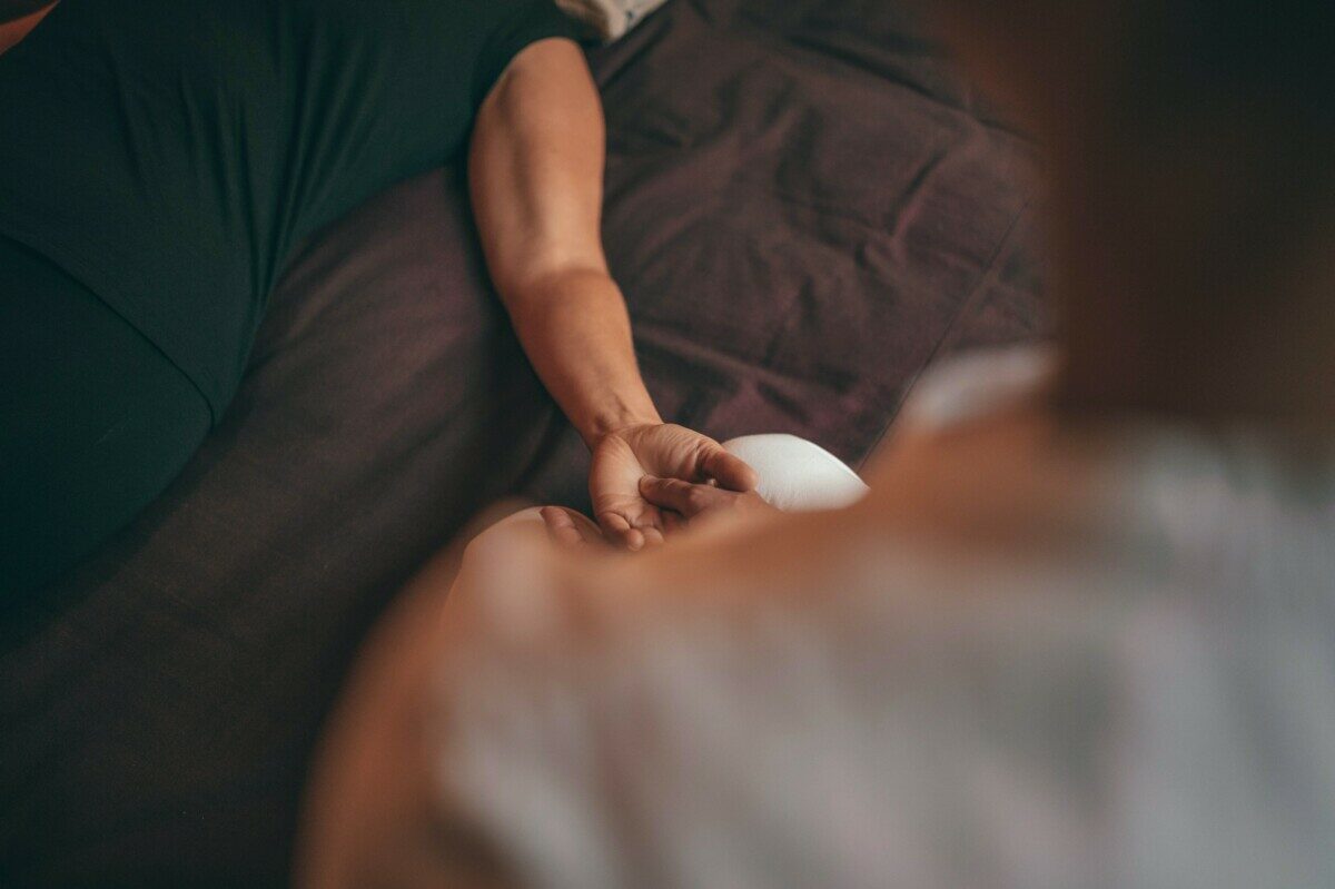 person in black shirt lying on bed