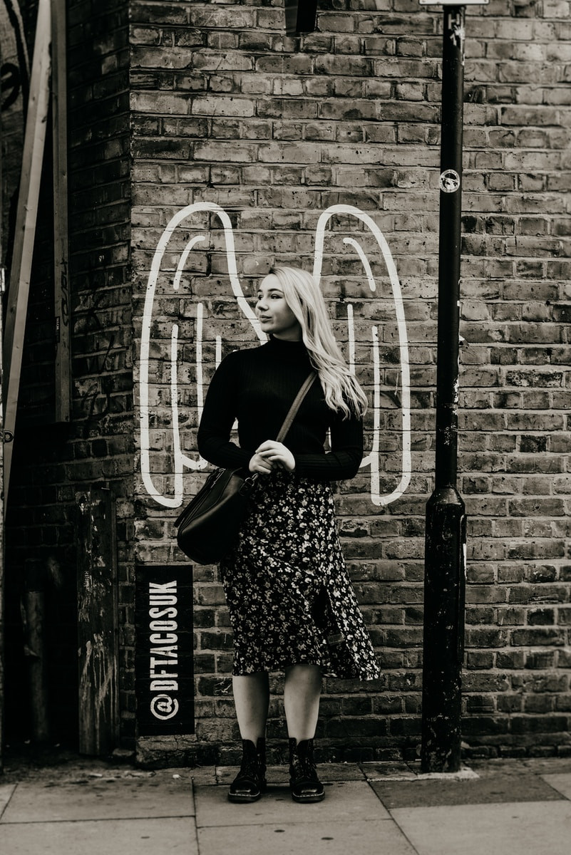 grayscale photo of woman standing looking at right side