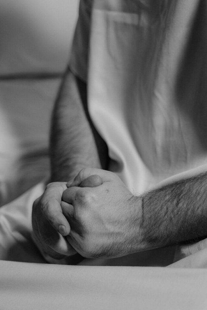 Grayscale Photo a Man with His Hands Together