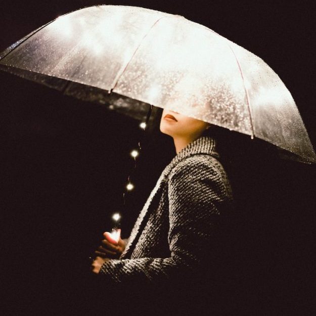 a woman holding an umbrella in the dark