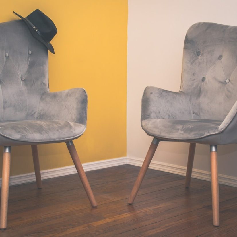 gray padded chair on brown wooden floor