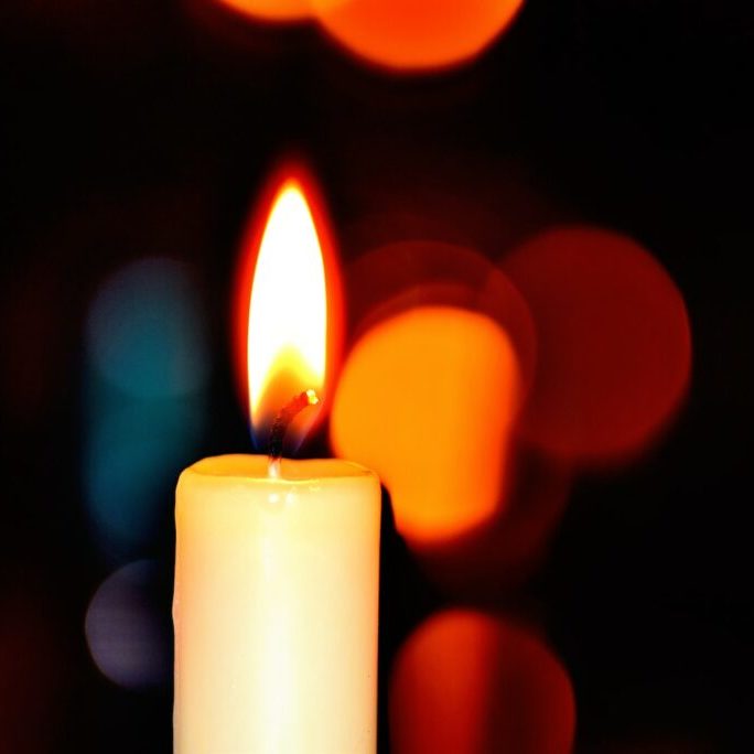 white candle in bokeh photography