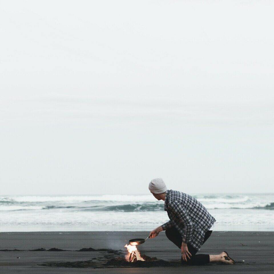 person cooking on seashore