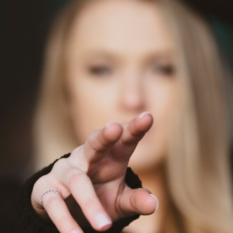 woman with blonde hair holding her face